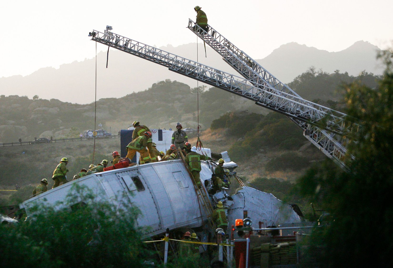 (LC: 20. srpnja-22.) Vatrogasci rade na spašavanju žrtve nakon što se Metrolinkov prigradski vlak na putu od Union Stationa u Los Angelesu do Oxnarda sudario s teretnim vlakom u području Chatswortha, 12. rujna 2008. Više od 300 vatrogasaca radi na gašenju plamena i spašavanje žrtava, prema vatrogasnoj službi Los Angelesa. Autorstvo slike: Alamy | REUTERS/Gus Ruelas (SJEDINJENE DRŽAVE) | ID: 2D1M052