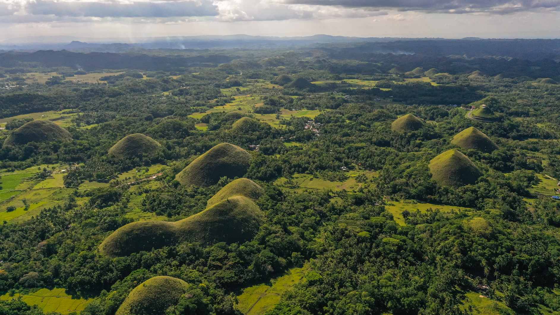 Hiwwele tëscht Akerland. Chocolate Hills natierlech Landmark, Bohol Insel, Philippinnen. © Bildkreditt: Alexey Kornylyev | Lizenzéiert vun DreamsTime, ID: 223476330