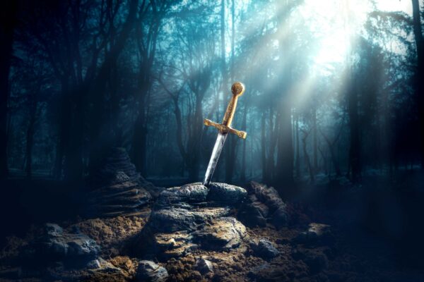 Excalibur, sword in the stone with light rays and dust specs in a dark forest