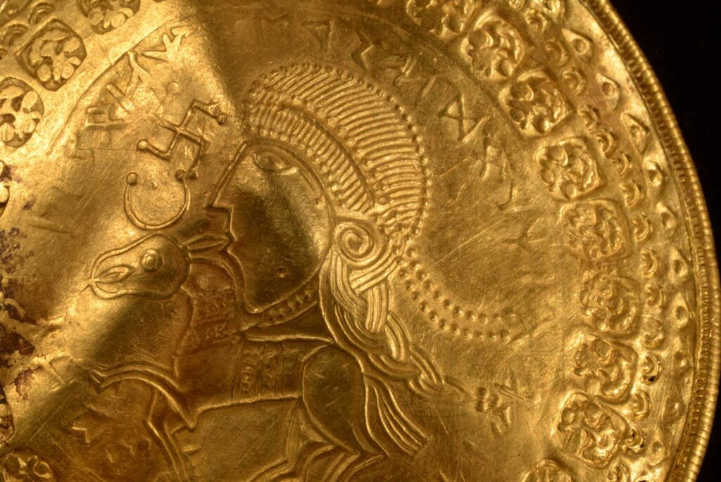 کتیبه "او مرد اودین است" به صورت نیم دایره گرد بالای سر یک شکل روی یک براکته طلایی که در اواخر سال 2020 در ویندلف، دانمارک کشف شد، دیده می شود. دانشمندان قدیمی ترین اشاره شناخته شده به خدای نورس اودین را بر روی یک طلا شناسایی کرده اند. دیسکی که در غرب دانمارک کشف شد.