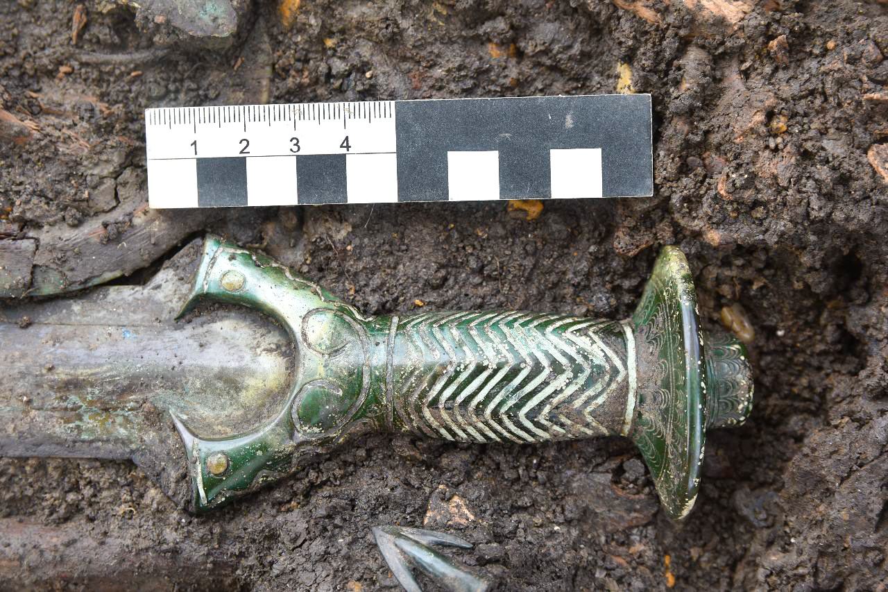 The bronze hilt has turned green since it was crafted in the middle Bronze Age. The sword was accompanied by arrow heads, one of which can be seen here.