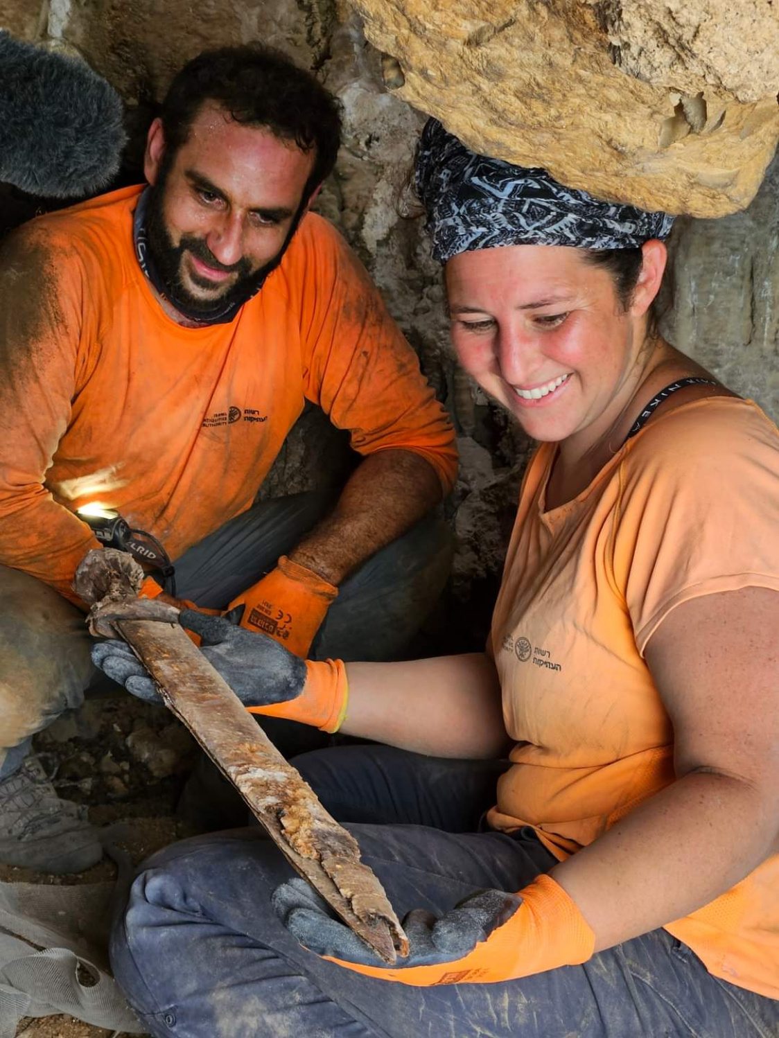 Archaeologists Oriya Amichay and Hagay Hamer removing one of the Roman swords from the crevice where they were hidden. 